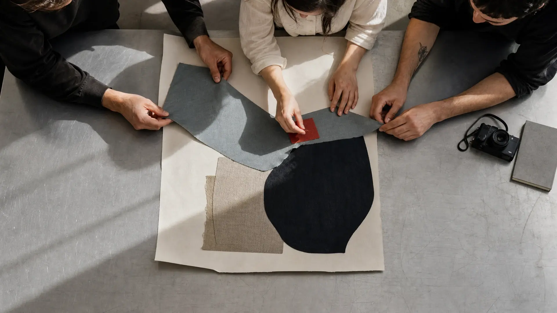 Illustrative image of people arranging fabric and paper.